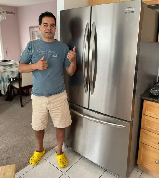 Customer beside a French-door refrigerator after a repair
