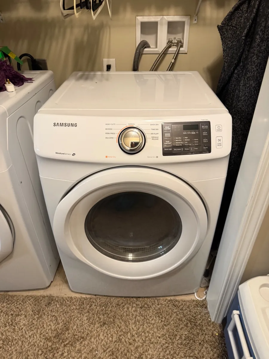 White Samsung front-load dryer in a laundry closet