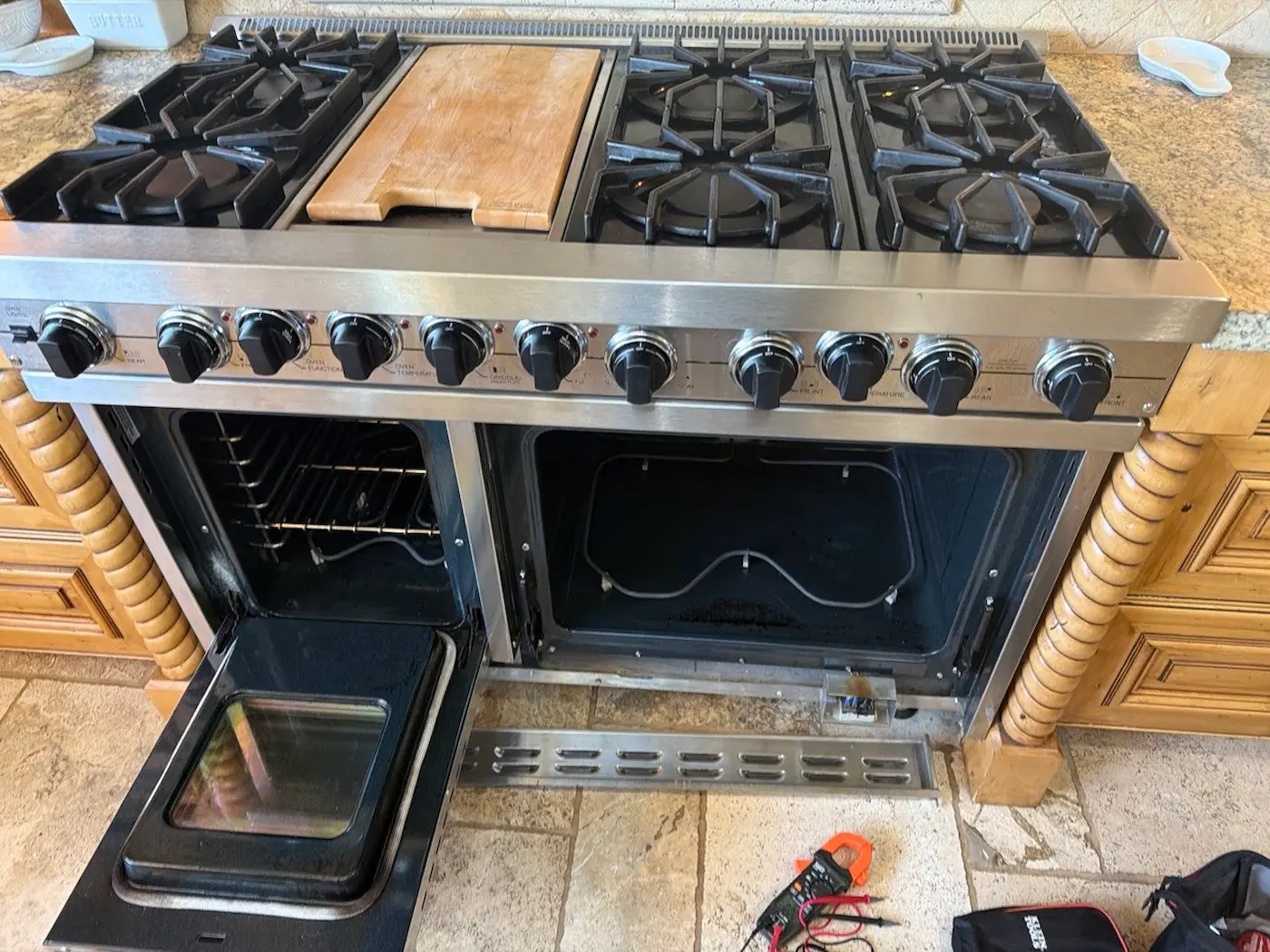 Viking range with both oven doors open during a repair